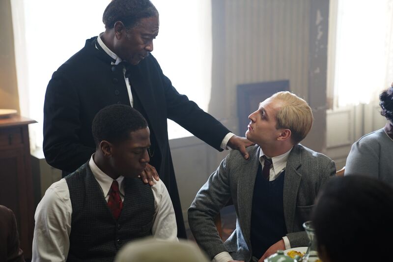 Bonhoeffer film still: a pastor rests his hands on the shoulders of Bonhoeffer and a friend