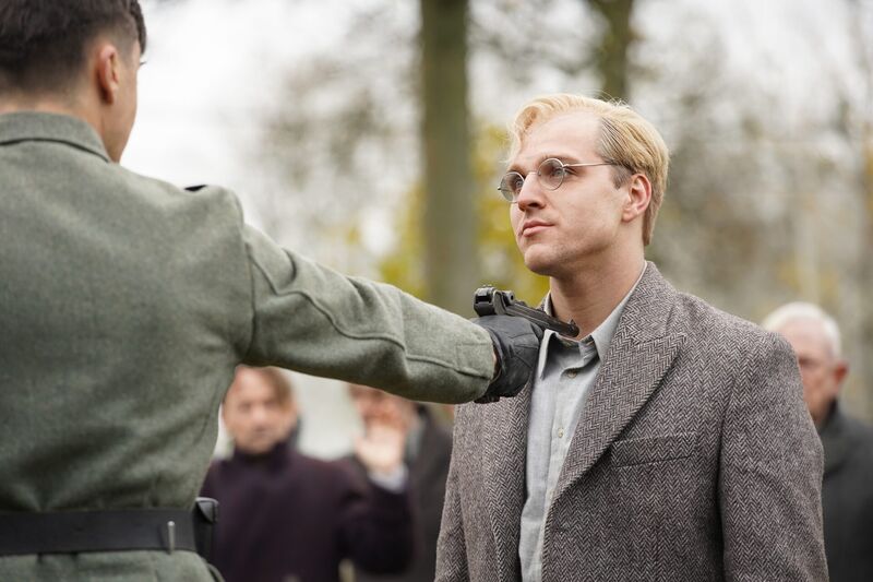 Bonhoeffer film still: a soldier stops Dietrich Bonhoeffer on the street